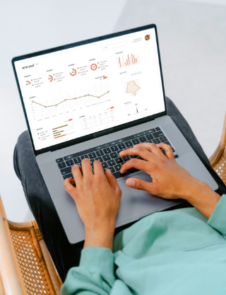 A person's hands typing on a laptop which displays a complex data